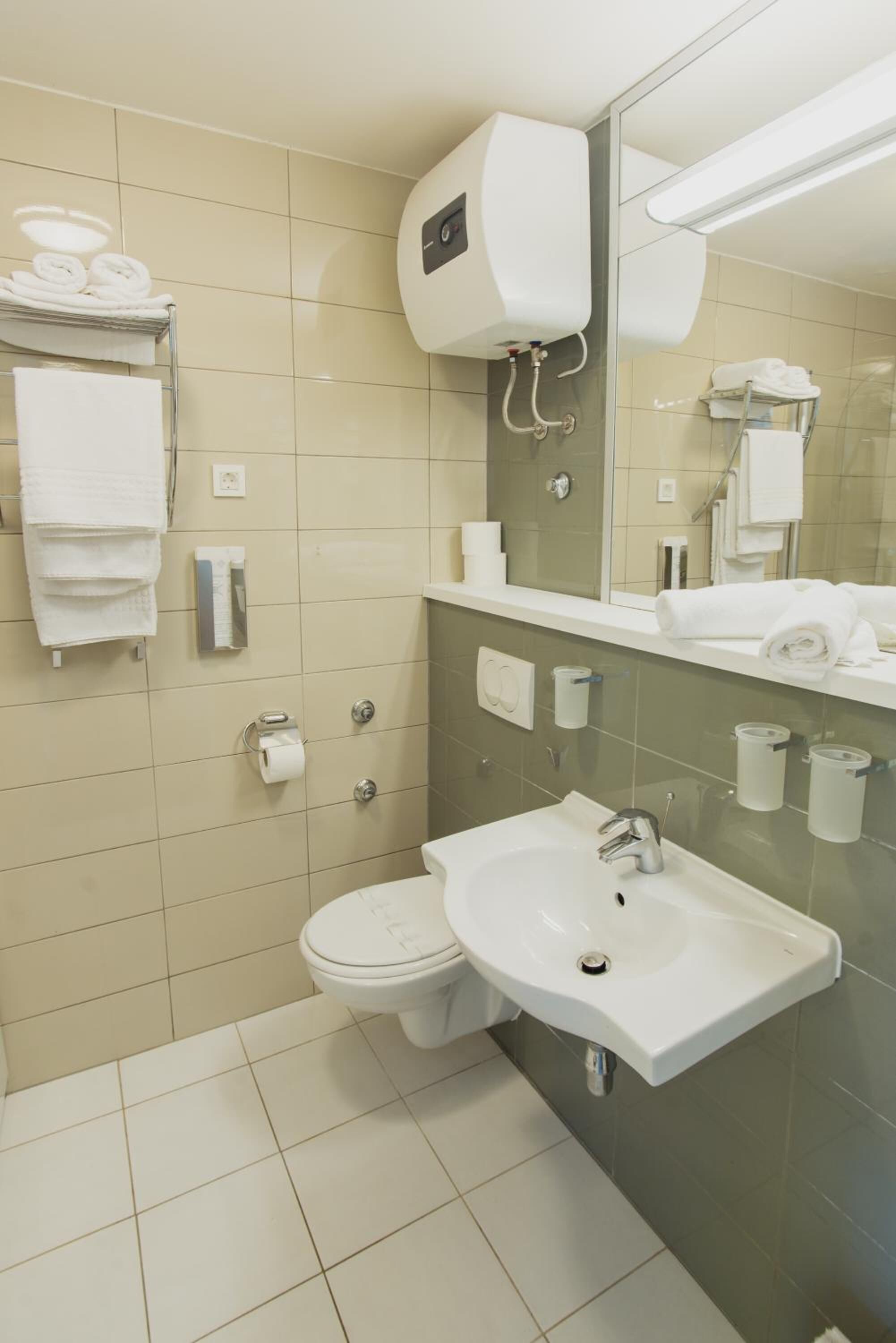 A modern bathroom with a toilet, sink, and towel rack.