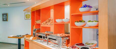 Un dispositiu de buffet amb diferents aliments i una zona de servei personal.