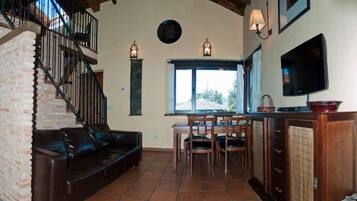 Una sala de estar con una escalera, un comedor y una cocina.