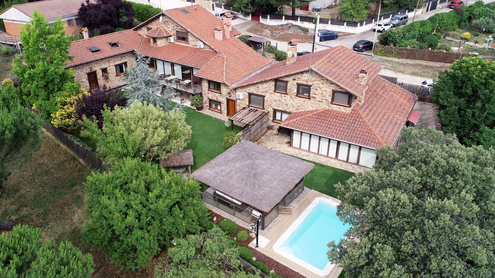 Propiedad residencial con varias casas, piscina y jardín bien cuidado.