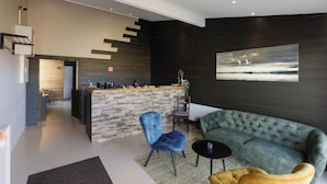 A modern interior with a kitchen area, a sofa, and a dining table. - Karuna Guesthouse (Skagafjörour)