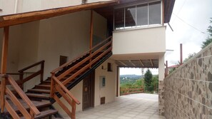 A two-story building with a wooden staircase leading to a balcony.