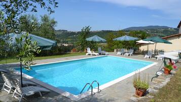 Piscine extérieure, parasols de plage, chaises longues