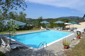 Piscine extérieure, parasols de plage, chaises longues