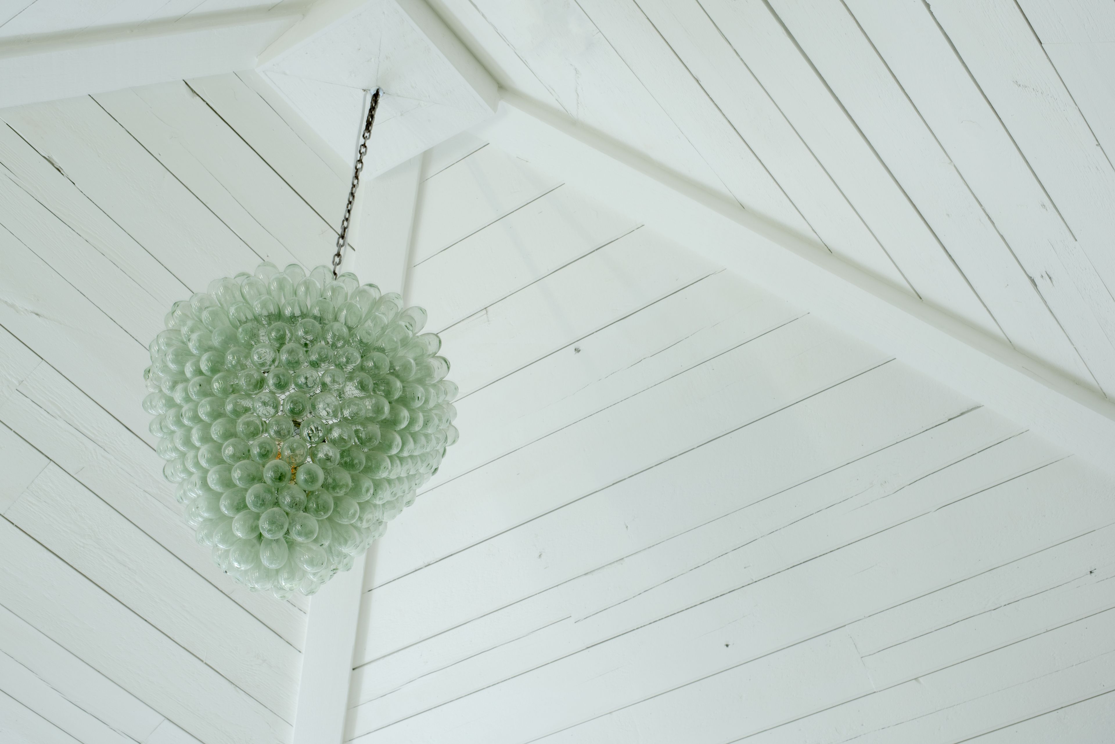 A ceiling with a unique spherical light fixture.