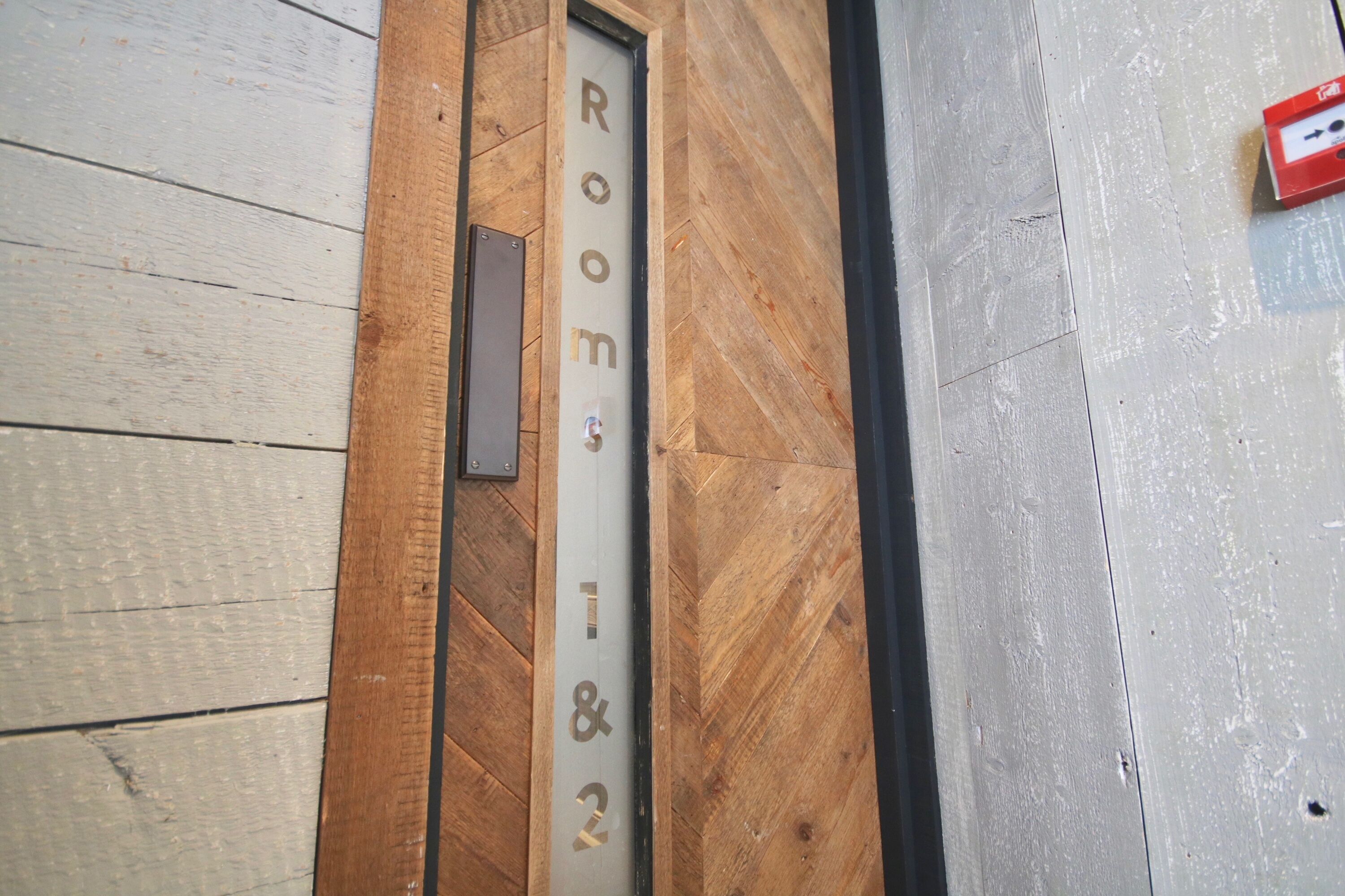 Une porte en bois sur laquelle on peut apercevoir le nom « ROM ».