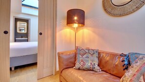 Um quarto com uma cama, uma mesa de cabeceira, um abajur e um espelho na parede.