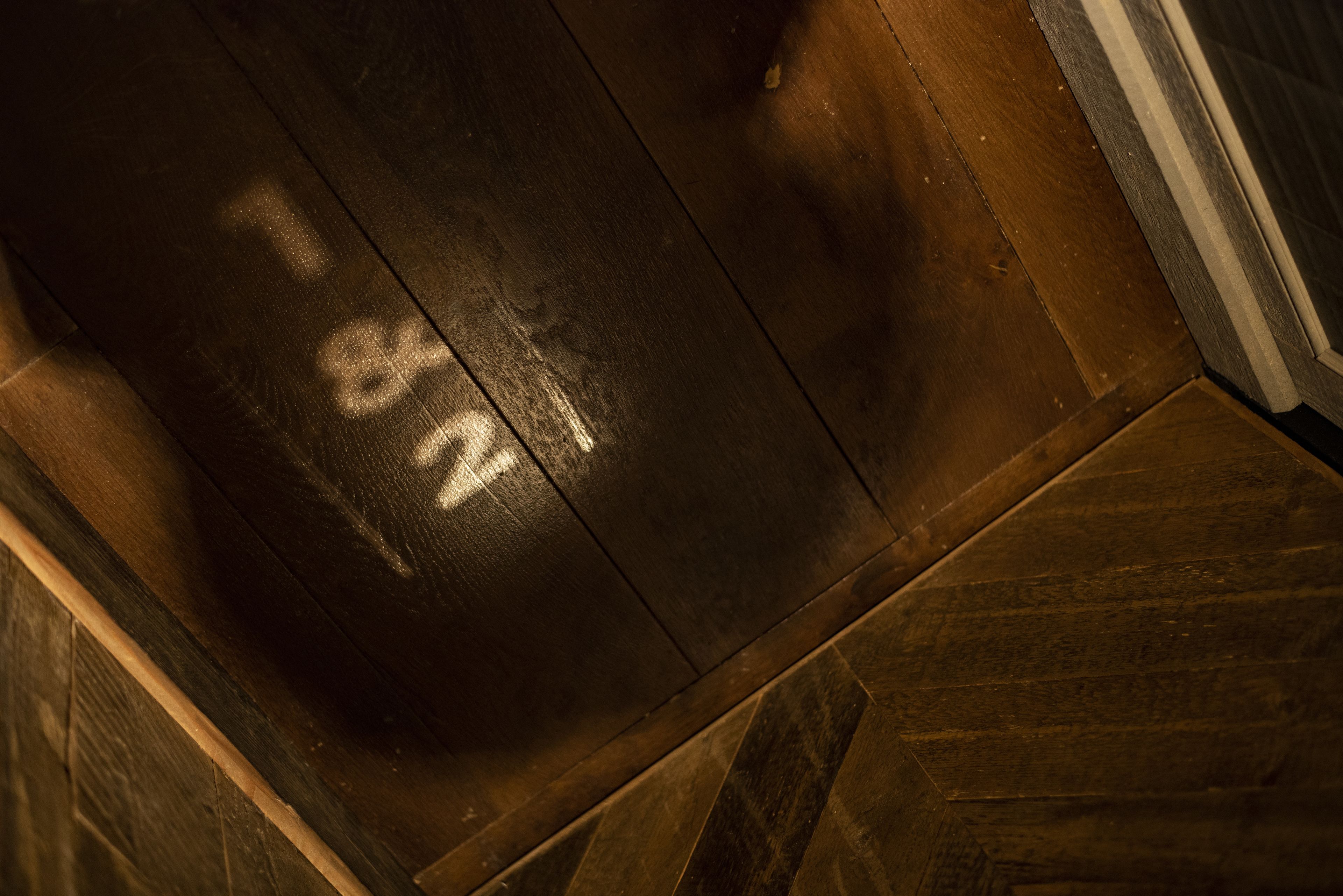 A close-up of a wooden floor with a herringbone pattern and a number "42" visible.