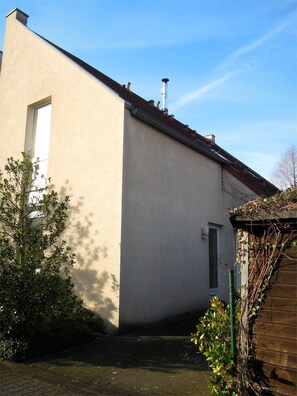 A building with a flat facade, a chimney, and a door.