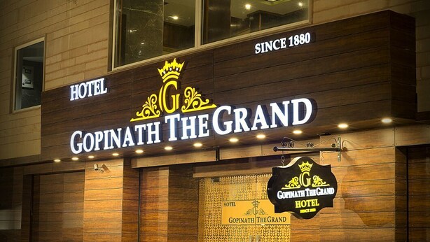 Un hotel llamado 'Gopinath The Grand' con fachada de madera y un cartel que indica que fue fundado en 1880.