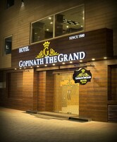 Un hotel llamado 'Gopinath The Grand' con fachada de madera y un cartel que indica que fue fundado en 1880.