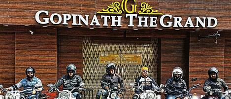 Ένα ξενοδοχείο με το όνομα «Gopinath The Grand», με μια επιγραφή και πέντε μηχανές σταθμευμένες μπροστά του.