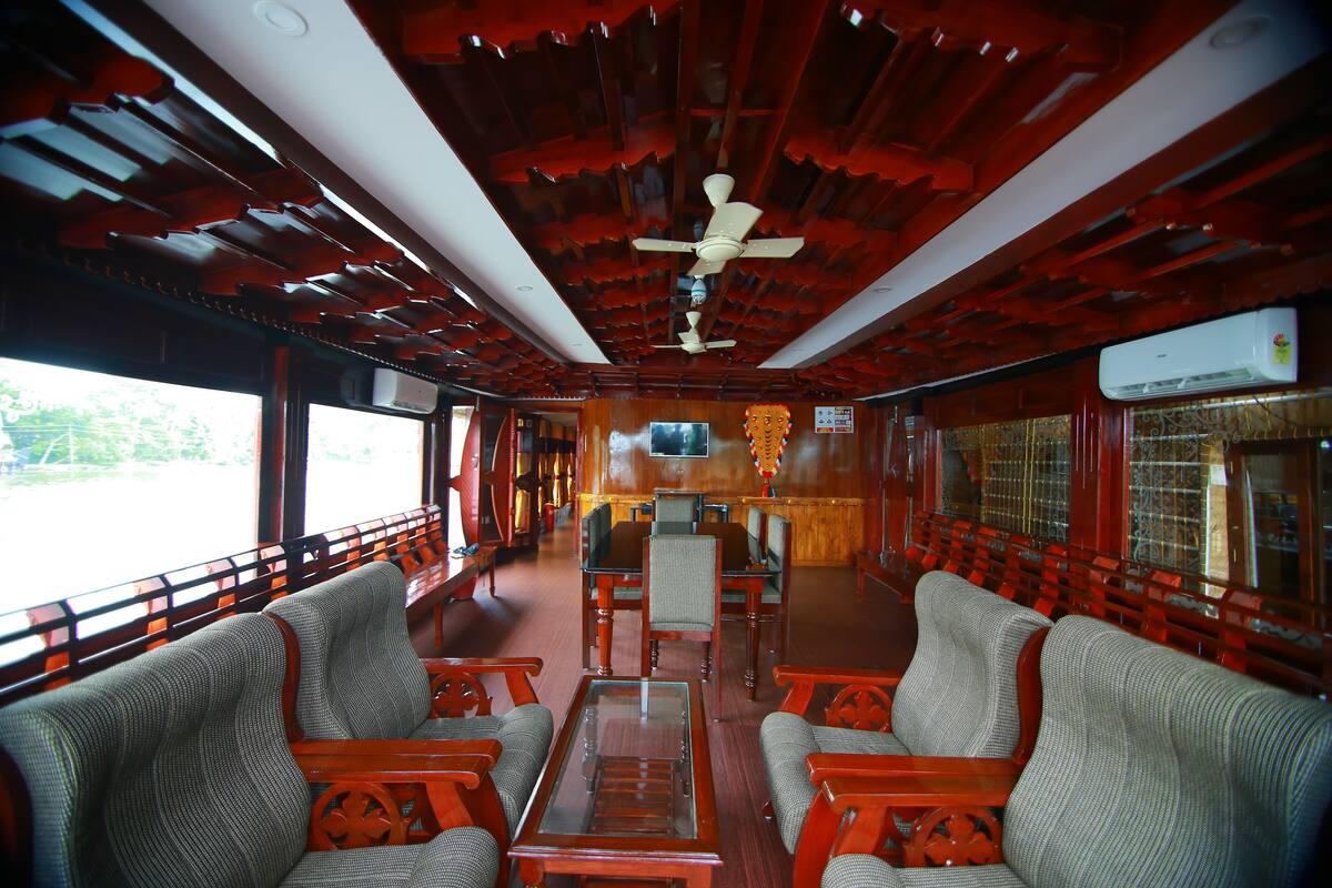 A train car with wooden paneling, a central table, and seating along the sides.