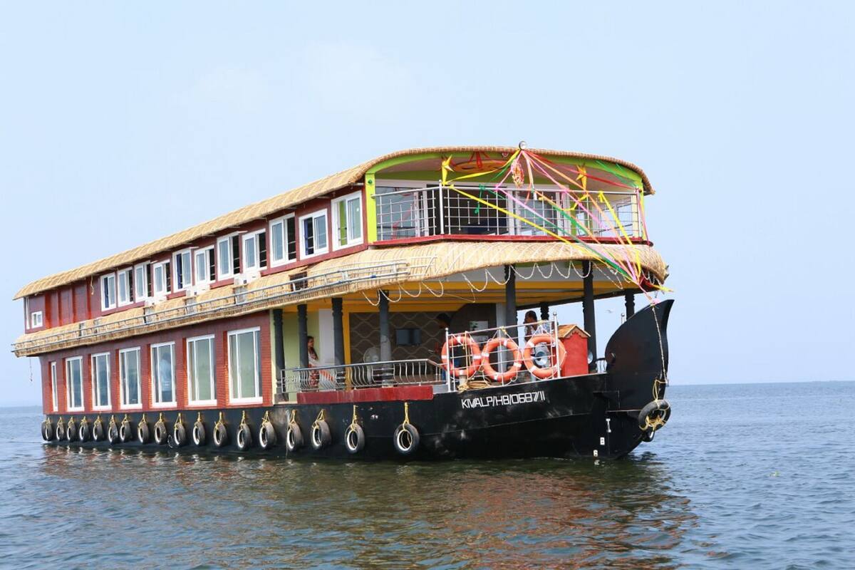 A double-decked boat with a thatched roof, windows, and a lifebuoy.