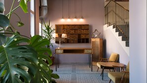 Een modern interieur met een houten console tafel, twee stoelen, een kamer met een patroon op de vloer en een trap.