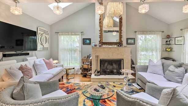 A spacious living room with a fireplace, two sofas, a coffee table, and a television. - Cute East Hampton Cottage w/ Patio - Walk to Beach (East Hampton)