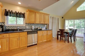 Enjoy meals in the kitchen with a large window offering a view of the outdoors and a dining area with a table and chairs.