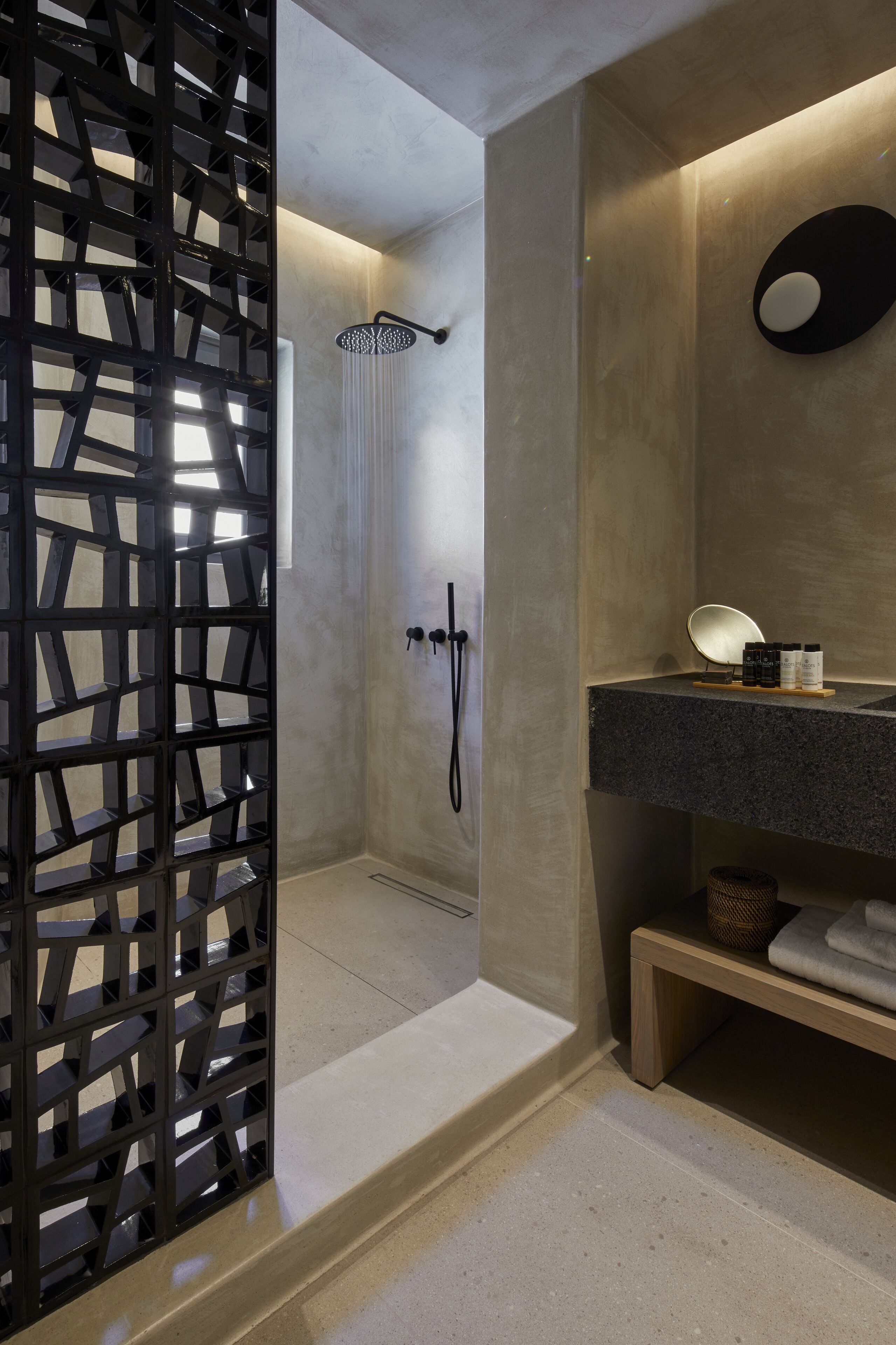 A modern bathroom with a shower, a sink with a mirror, and a decorative wall panel.