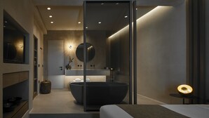 Un baño moderno con una bañera grande, un espejo y una lámpara redonda.