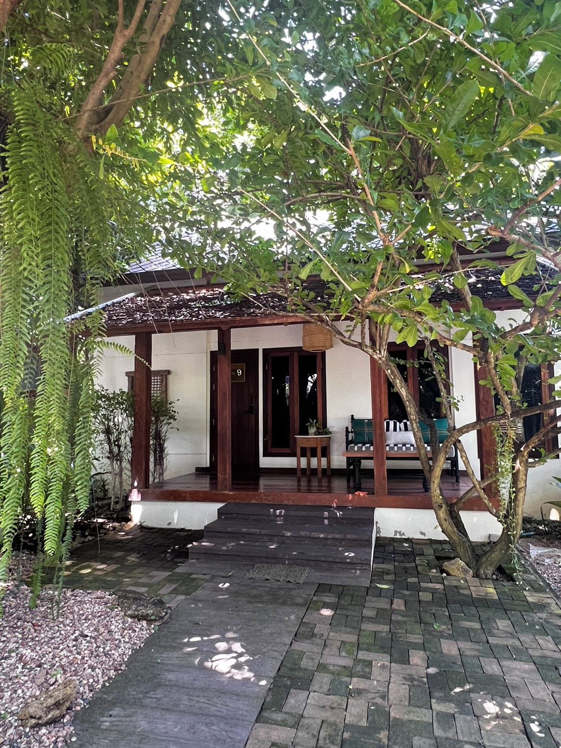 A traditional house with a wooden porch, a door, and a bench.