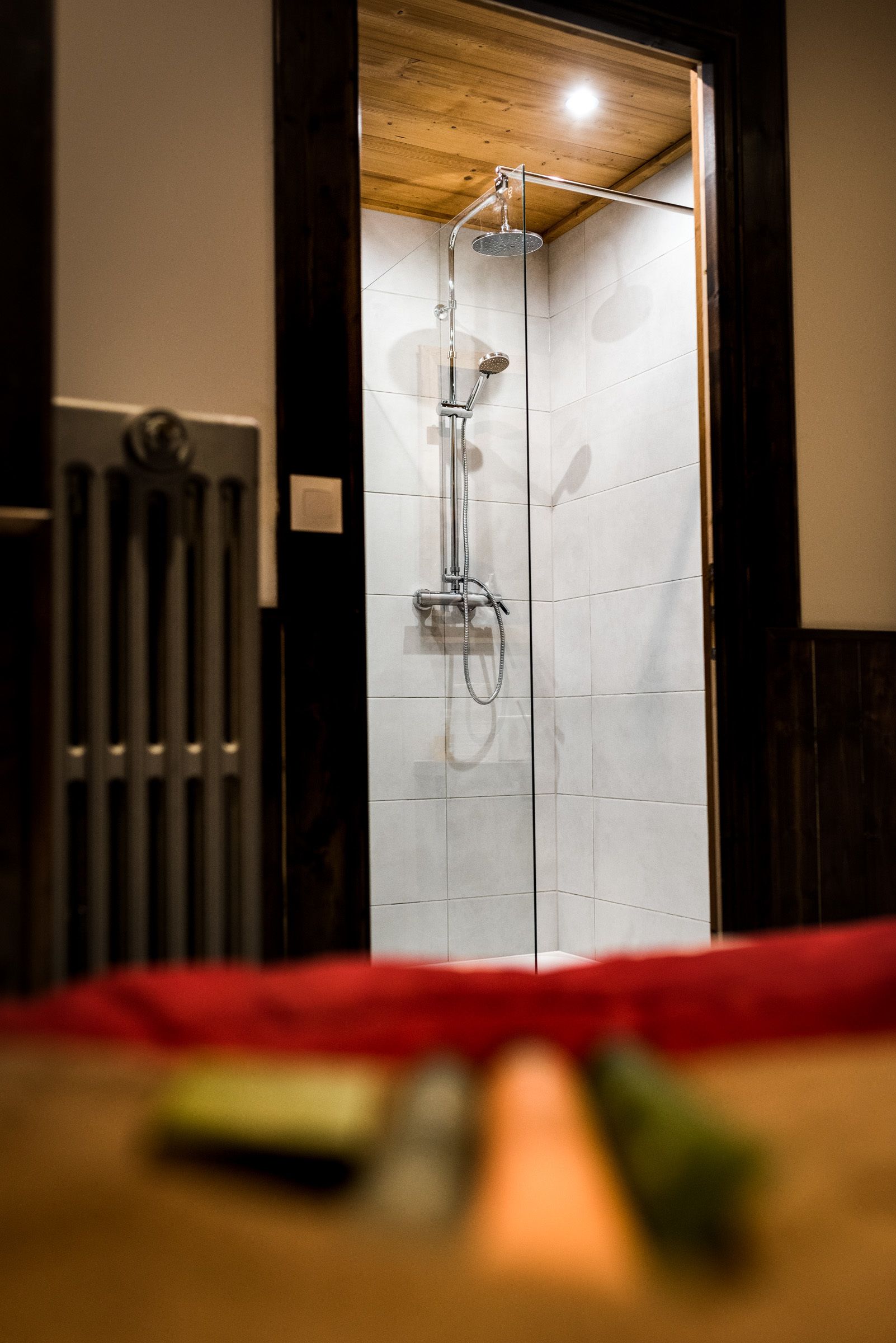 Une douche avec un plafond en bois et des murs carrelés.