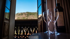 A view through a window with a bottle of wine and two glasses on a table.
