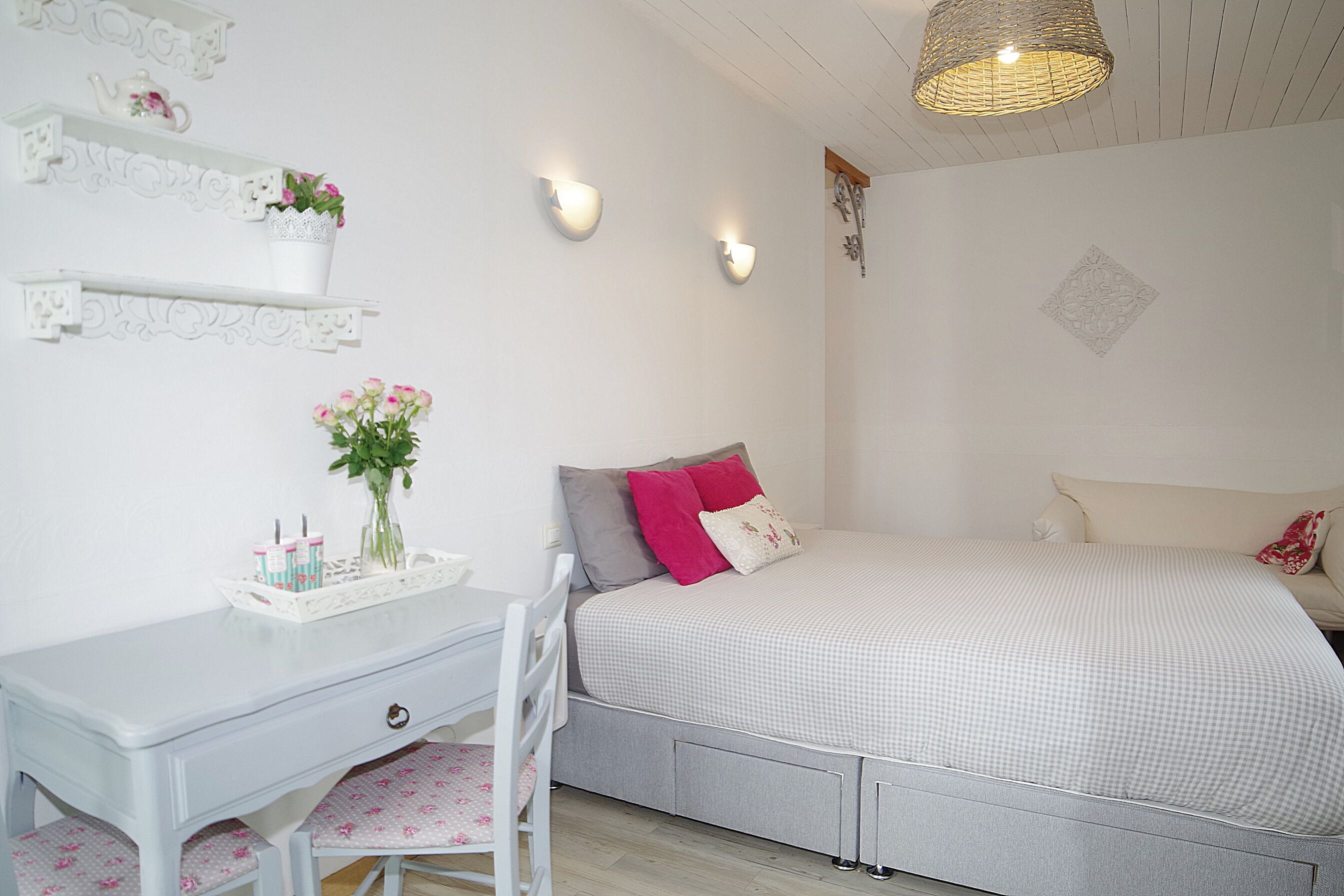 Un dormitorio con cama, escritorio y silla.