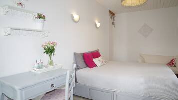 Un dormitorio con cama, escritorio y silla.