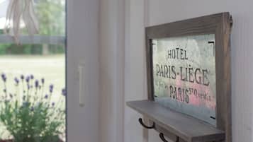 Um letreiro com o texto 'HOTEL PARIS-LIEGE' fixado em uma parede.