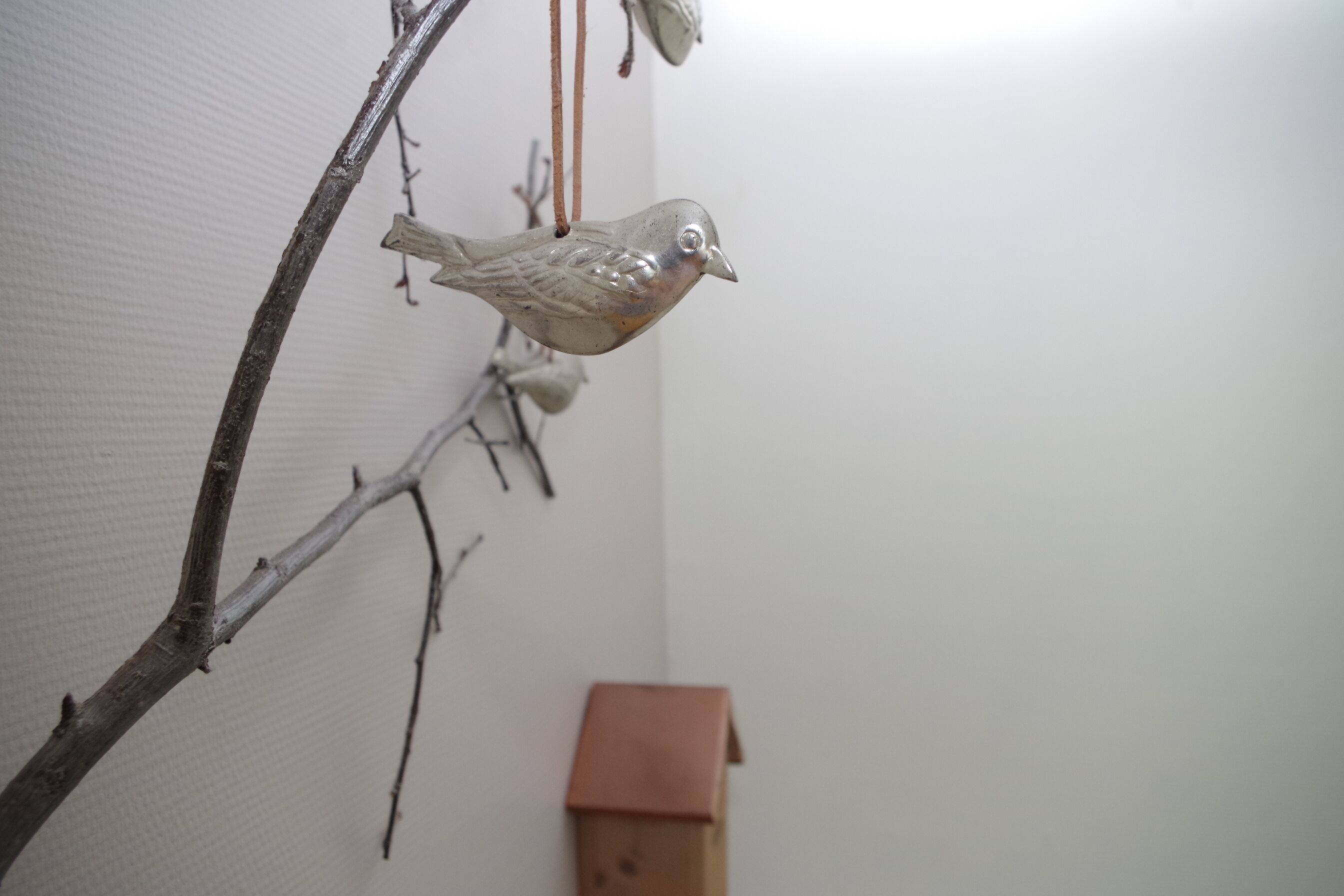 A bird-shaped ornament hanging from a branch.
