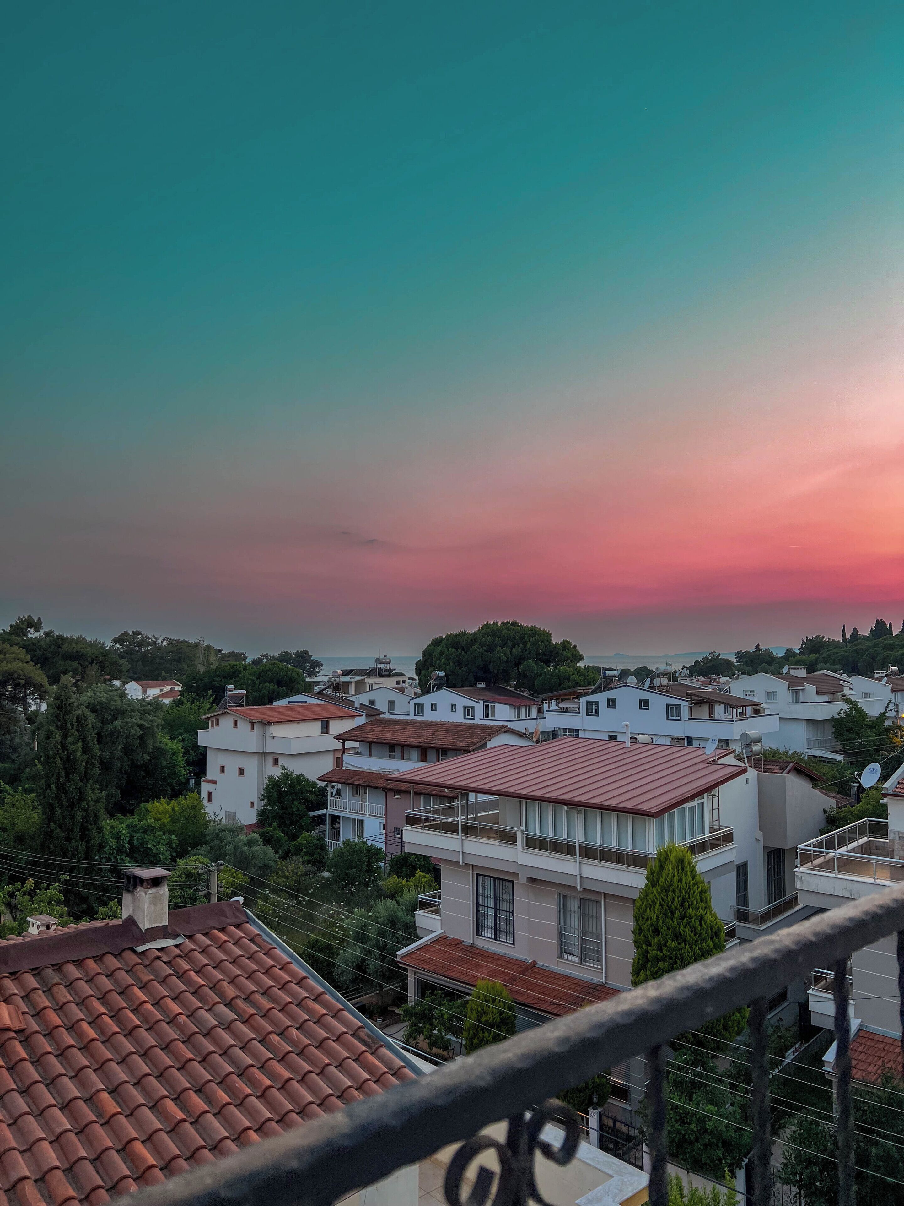 A residential area with houses, a balcony, and a clear sky.