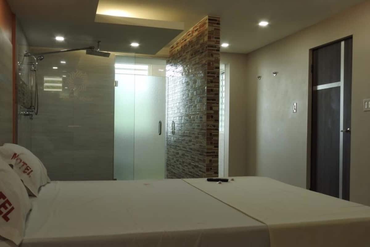 A bedroom with two beds, a shower, and a wardrobe.