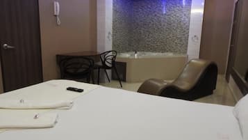 Una camera d'albergo con un letto, una scrivania, una sedia e una vasca da bagno.