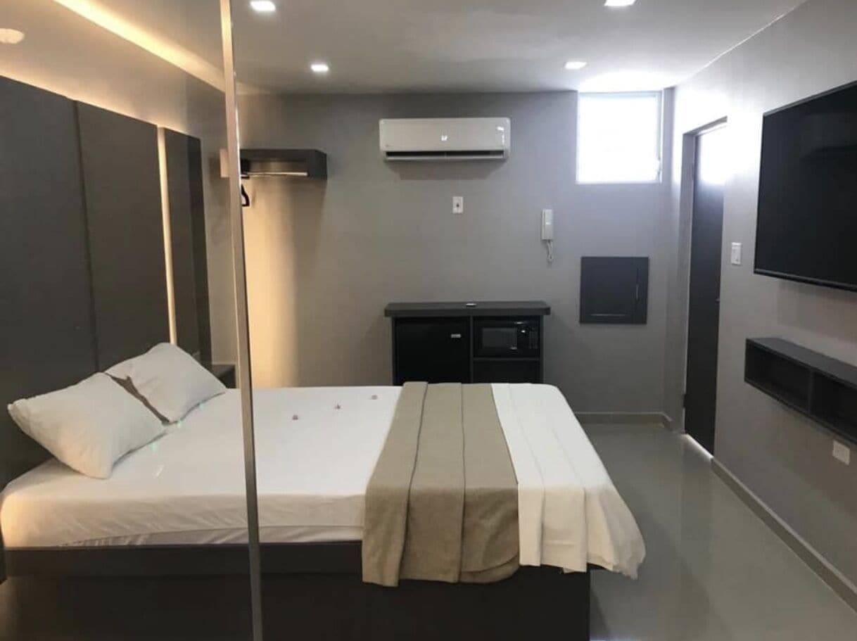 Une chambre d’hôtel moderne équipée d’un lit, de tables de chevet, d’un téléviseur à écran plat et d’un système de climatisation.