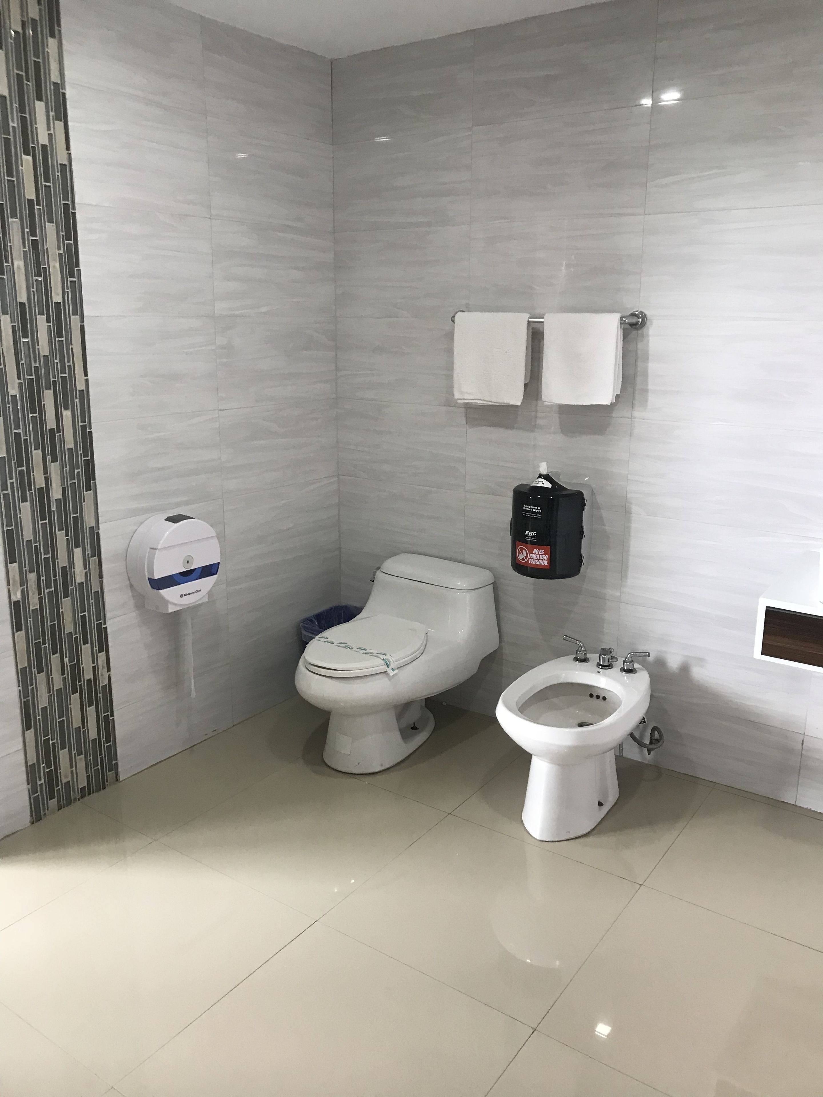 A modern bathroom with a toilet, bidet, and sink.