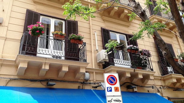 A multi-story building with balconies, some with flower boxes. - A Casa di Amelie (Palermo)