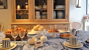 A dining table set with various dishes, glasses, and a buffet stand. - A Casa di Amelie (Palermo)