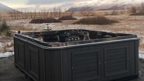 A hot tub in an outdoor setting with a mountainous backdrop. - Holt Inn (Holt)
