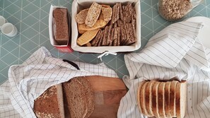 A variety of bread and crackers on a table with a checkered tablecloth.