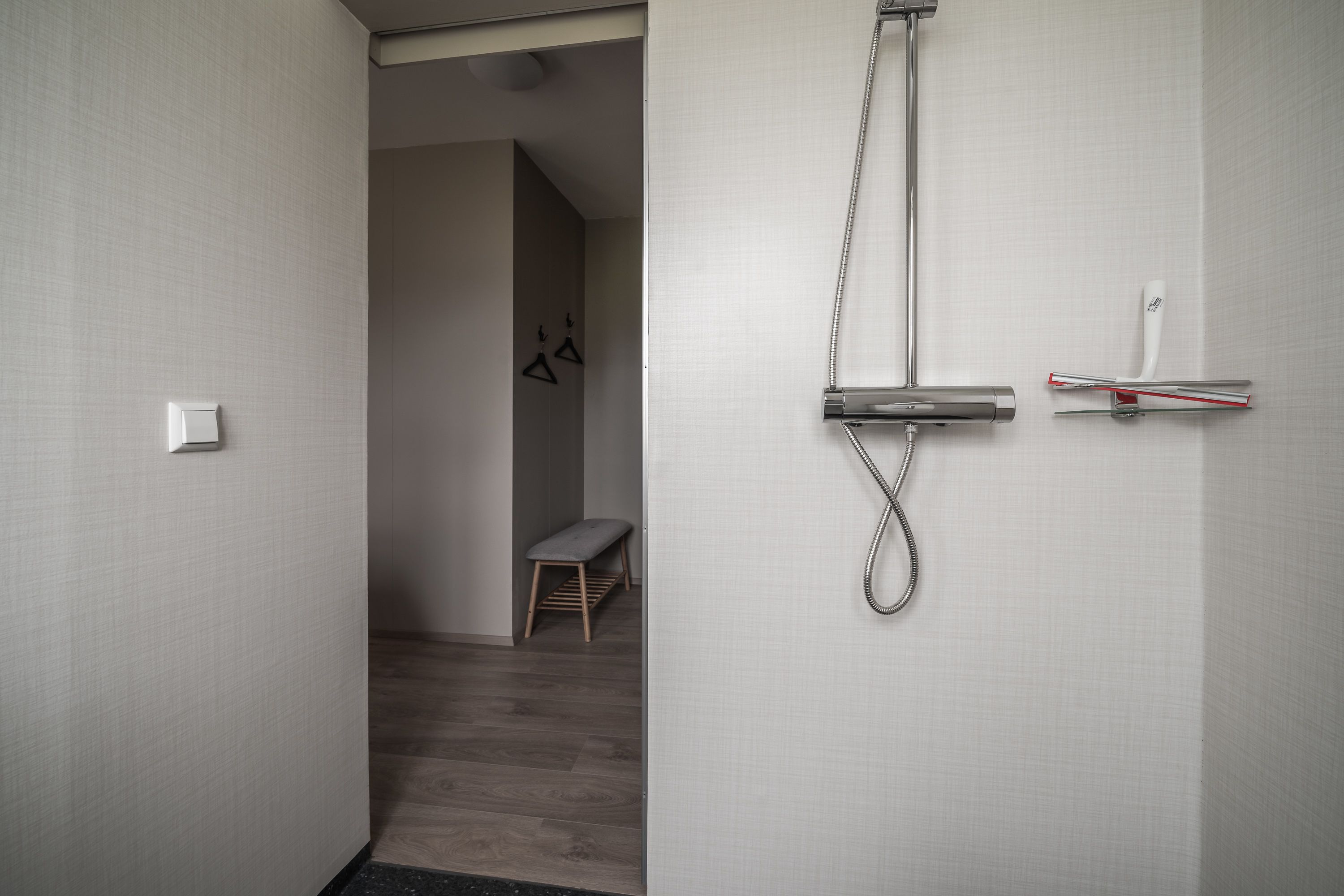 Ein modernes Badezimmer mit Dusche, Sitzbank und Handtuchhalter.
