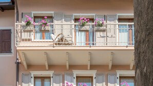 Un immeuble à plusieurs étages doté de balcons, chacun étant muni d’une rambarde et d’une petite fenêtre.