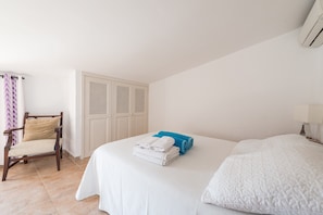 A hotel room with a bed, a chair, a wardrobe, and a window with curtains. - Country House "Coster" in a Quiet Location with Pool (POLLENSA)