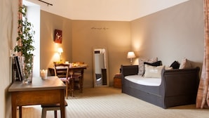 Un dormitorio acogedor con techo de madera, cama, escritorio y sofá.