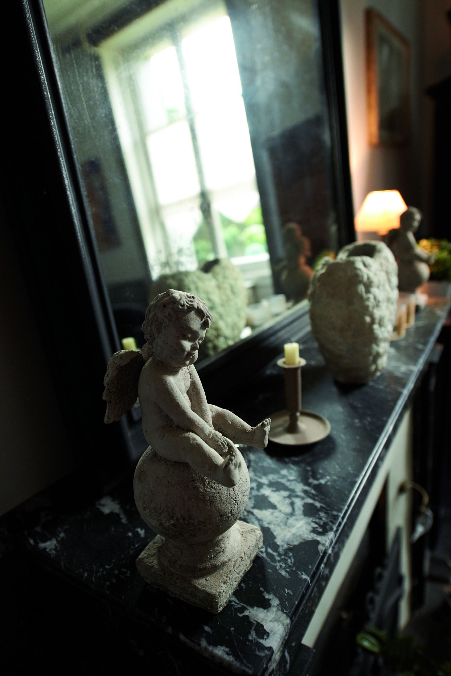 A statue of a child with wings on a marble surface.