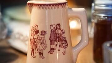 Une tasse en céramique au motif traditionnel, posée sur une surface en bois.