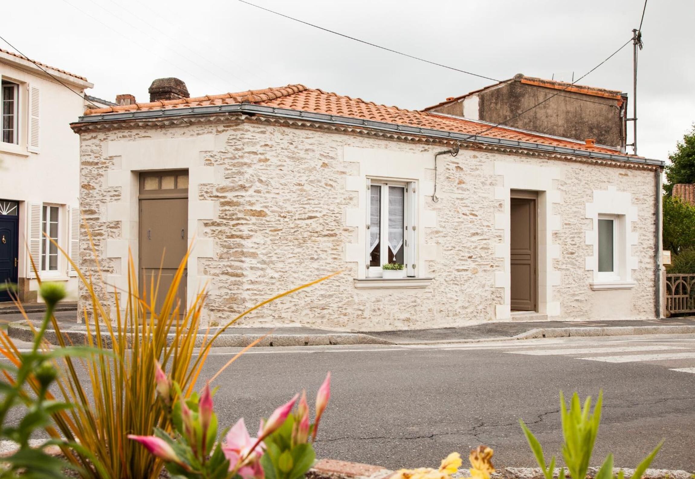 A small stone building with a tiled roof, a single door, and a window.
