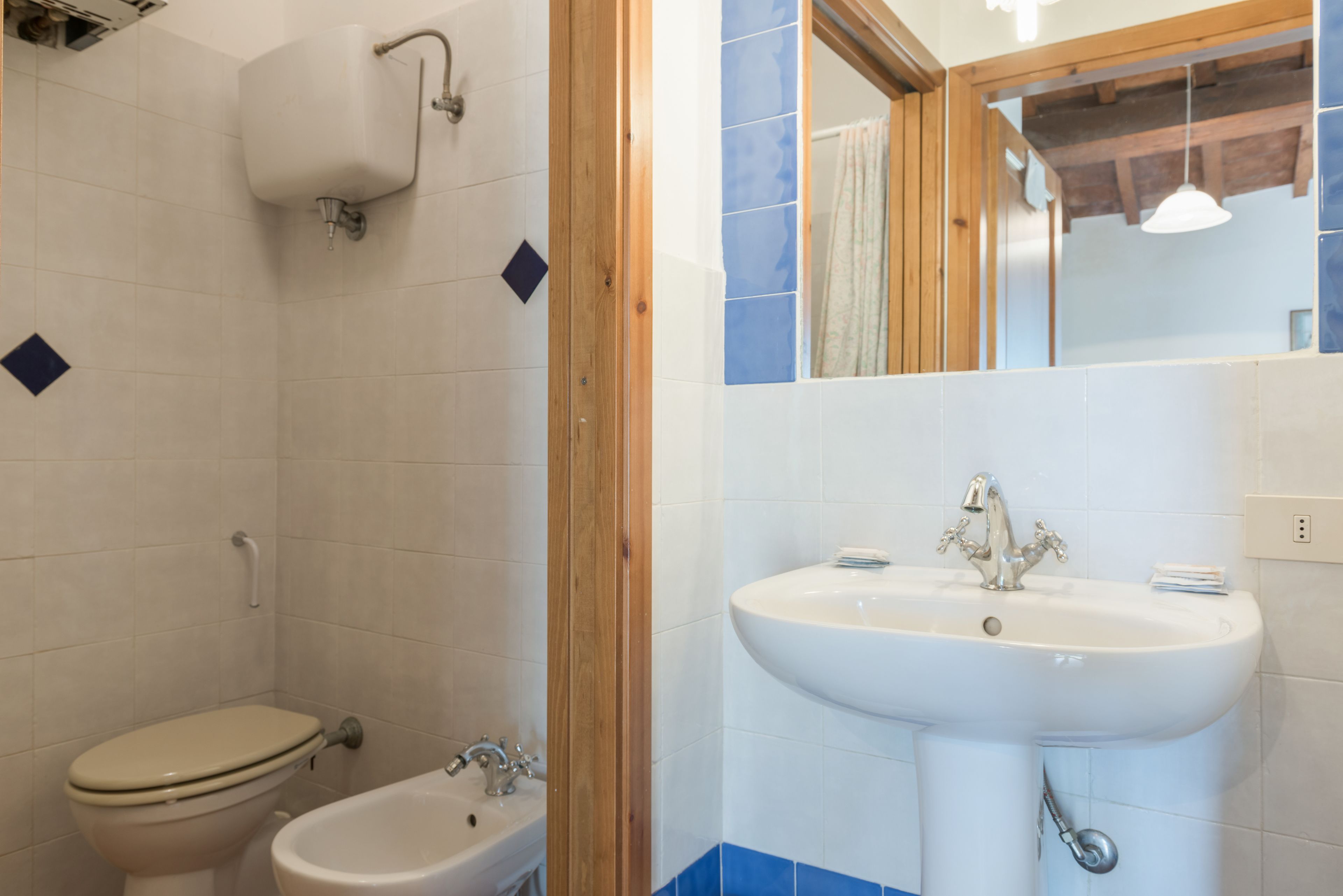 A bathroom with a toilet, bidet, and sink.