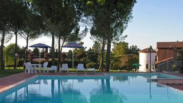 Een buitenzwembad, parasols voor strand/zwembad