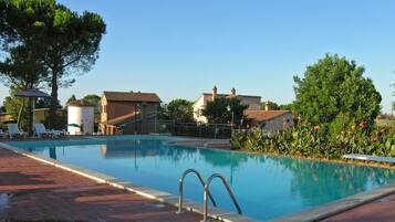 Een buitenzwembad, parasols voor strand/zwembad