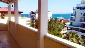 Un balcone con vista sul mare e sugli edifici circostanti.